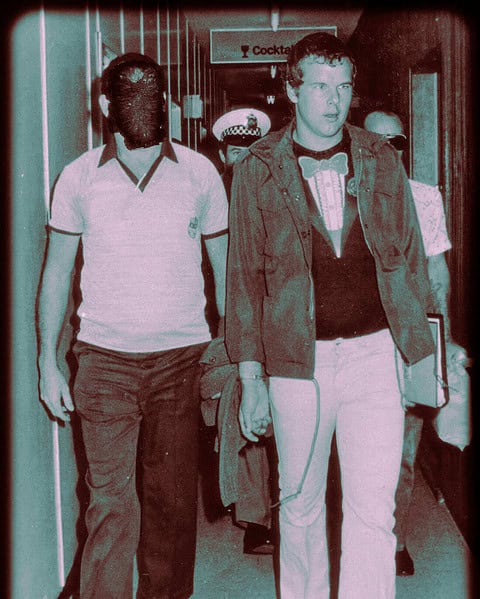 Vintage tinted photo of a young man walking with police officers indoors.