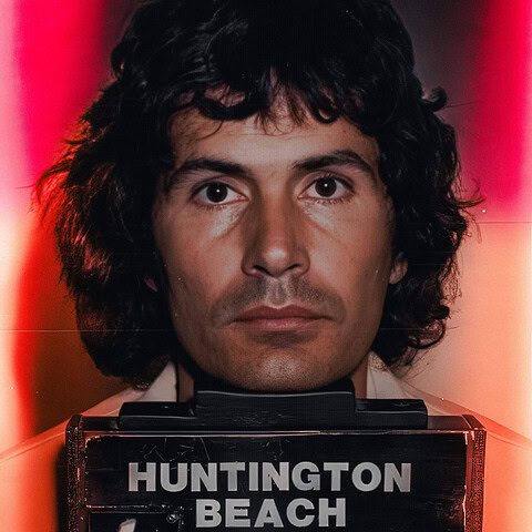 Close-up of a mugshot of a man with dark hair and serious expression.
