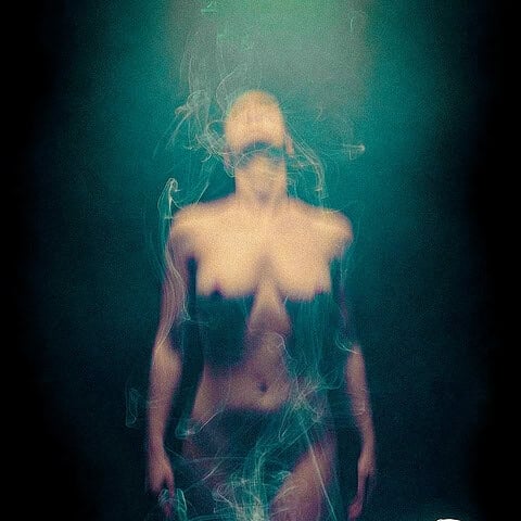 Surreal image of a woman on a bed with a ghostly figure rising, representing an out-of-body experience.