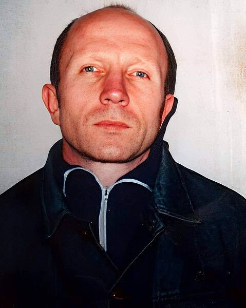 Portrait of a man with a serious expression, wearing a dark jacket.