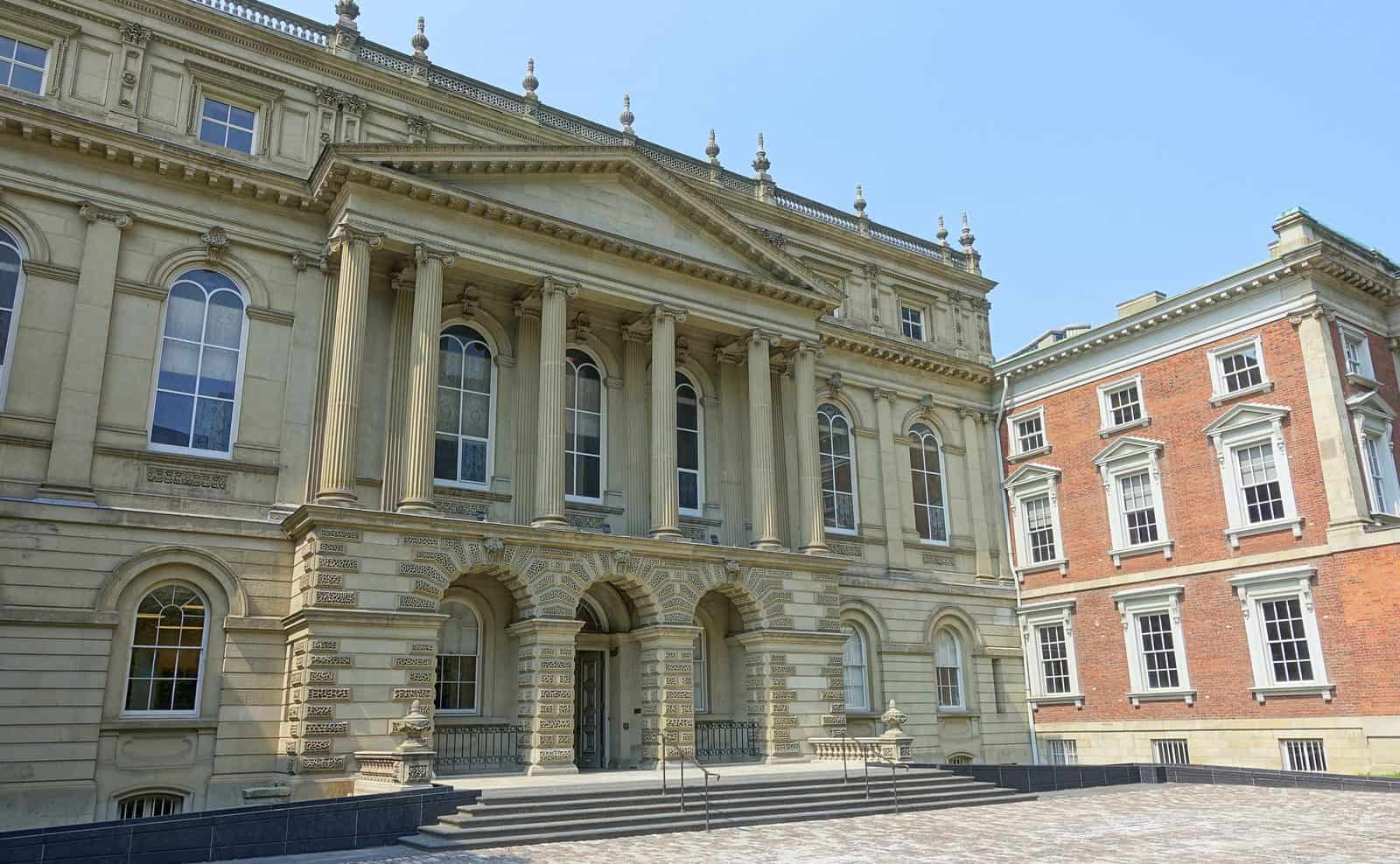 Neoclassical stone facade of Osgoode Hall in Toronto with a columned portico.
