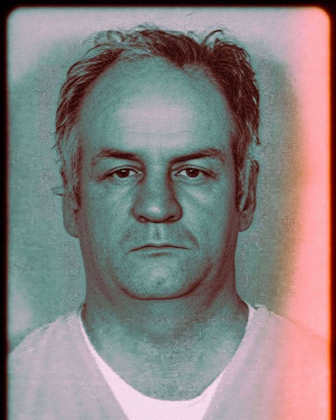 Close-up mugshot photograph of a middle-aged man with receding hair facing the camera.