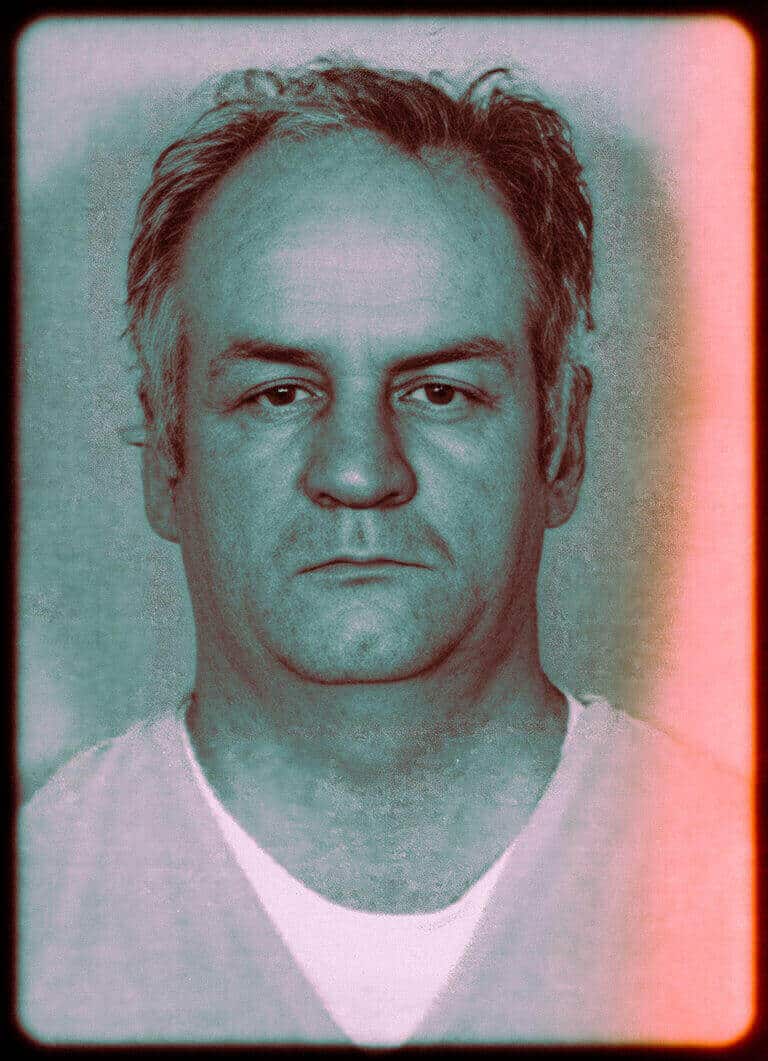 Close-up mugshot photograph of a middle-aged man with receding hair facing the camera.