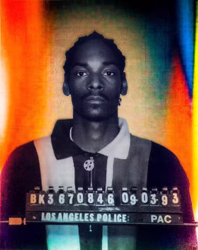 Colourised booking photo of rapper Snoop Dogg facing the camera above a booking number board dated 09-03-93.