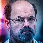Close-up of a man with glasses showing the dark side of human nature and evil.