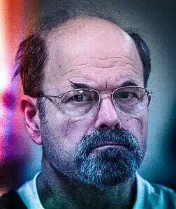 Close-up of a man with glasses showing the dark side of human nature and evil.
