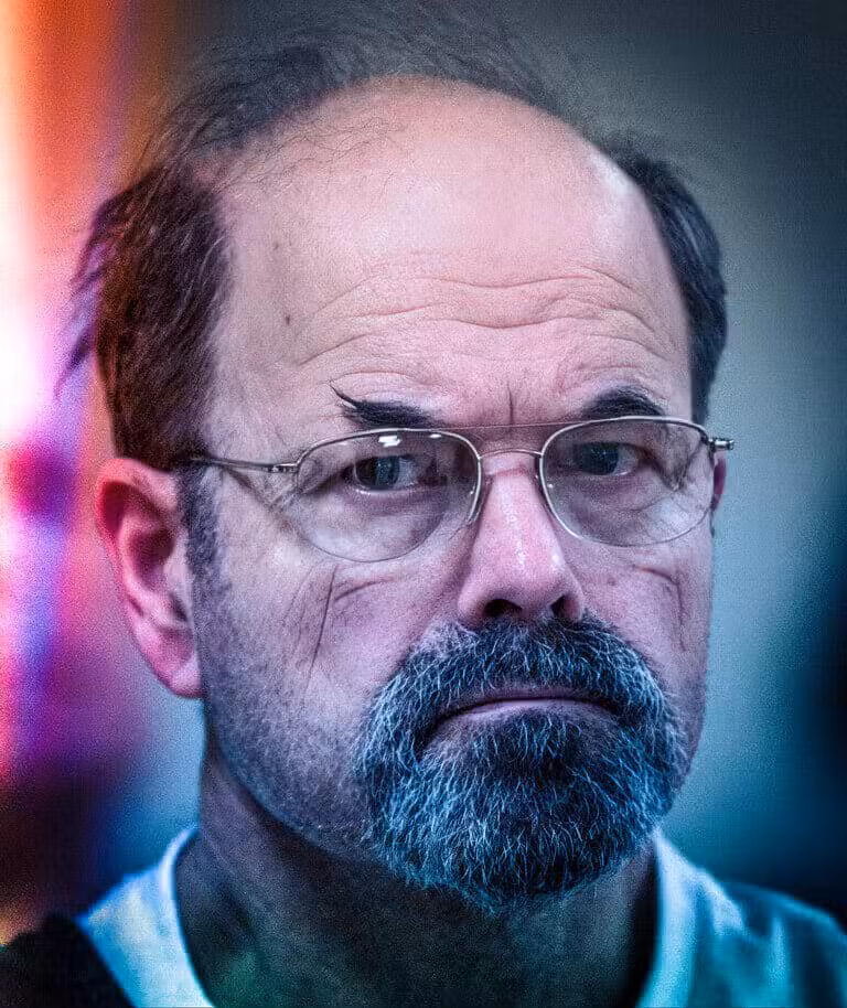 Close-up of a man with glasses showing the dark side of human nature and evil.
