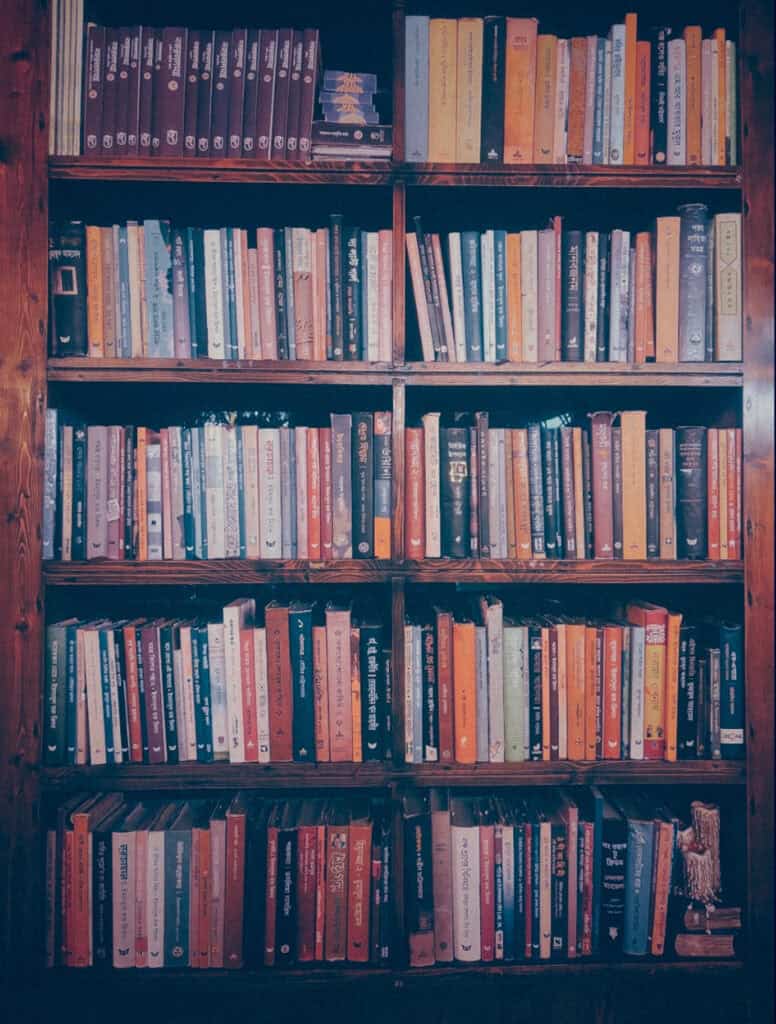 A wooden bookshelf tightly packed with rows of hardcover and paperback books.