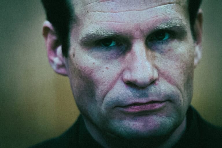 Close-up portrait photograph of a middle-aged man looking at the camera.