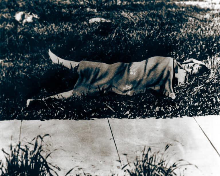 Archival 1947 press photograph of a covered scene in a Los Angeles vacant lot.
