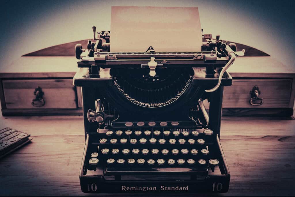 Erotophonophilia. Vintage Remington typewriter on a wooden desk with paper ready for typing.