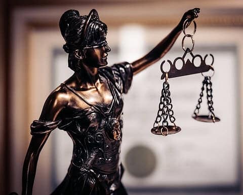 Bronze statue of Lady Justice with scales symbolizing justice and morality.