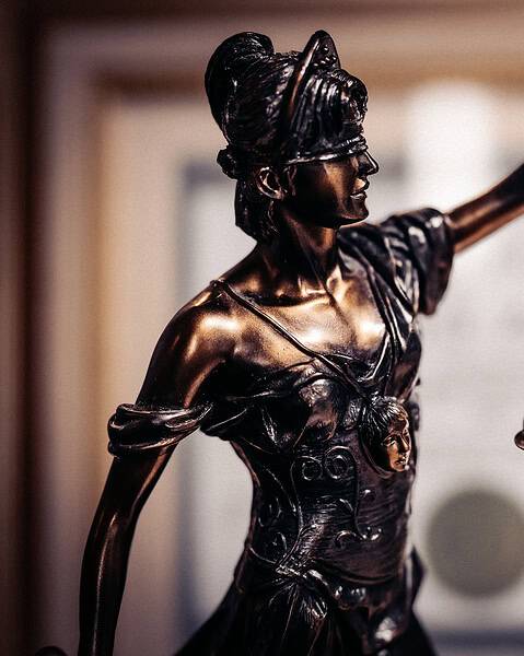Bronze statue of Lady Justice with scales symbolizing justice and morality.