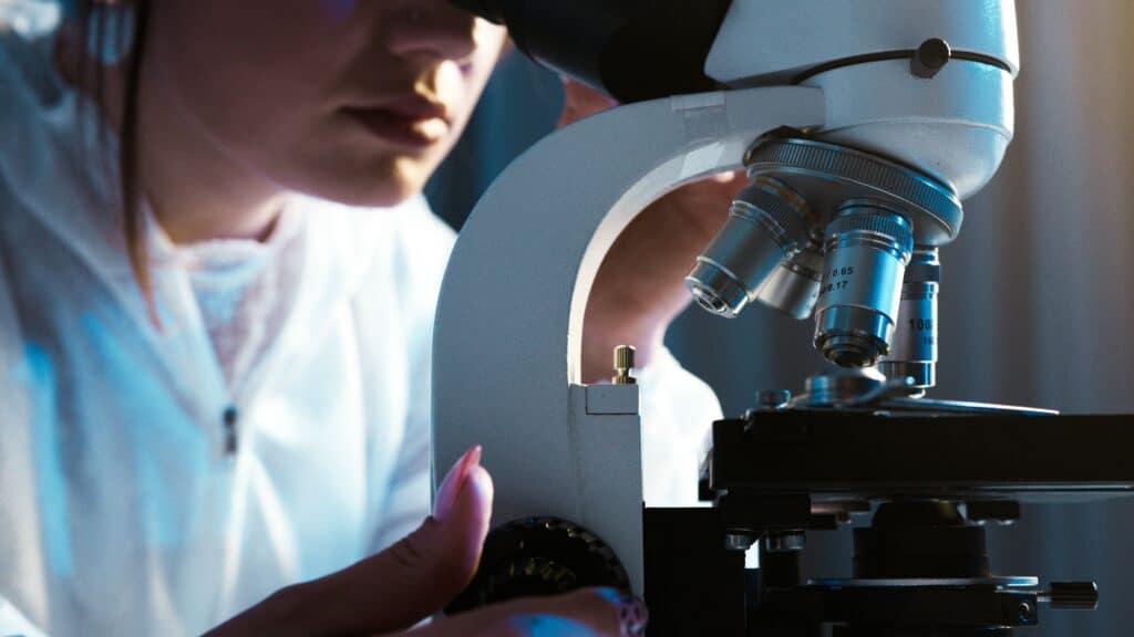 Laboratory scientist examining a sample through a microscope. sexual sadism disorder