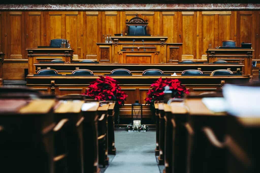 Empty courtroom with wooden walls and festive poinsettias in front.