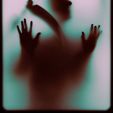 Faint silhouette of a person pressing against a foggy glass surface.