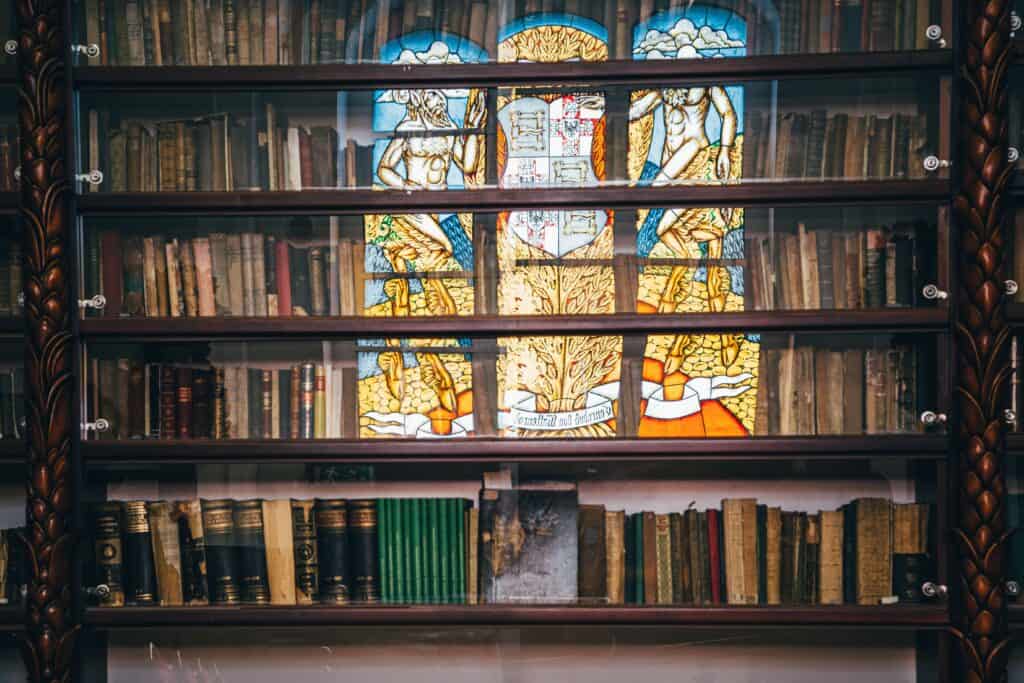what i snecrophilia? Shelves of antique medical and historical books in a vintage library.