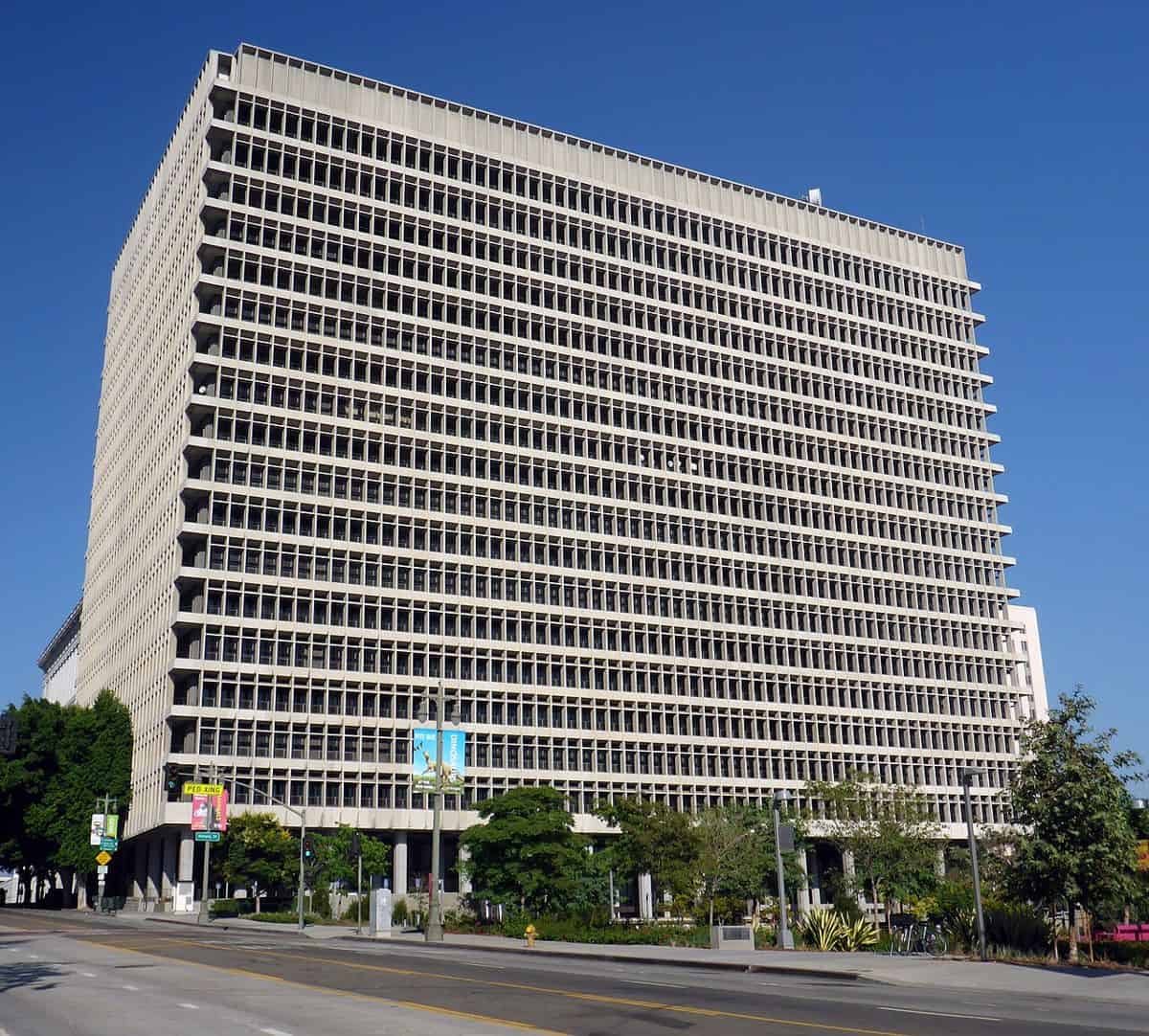 A tall concrete and glass tower with horizontal window bands, the Clara Shortridge Foltz Criminal Justice Center in downtown Los Angeles, under a clear blue sky