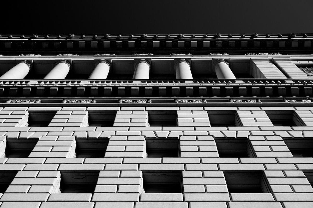The granite façade of the Hall of Justice in downtown Los Angeles, with tall arched windows and columns