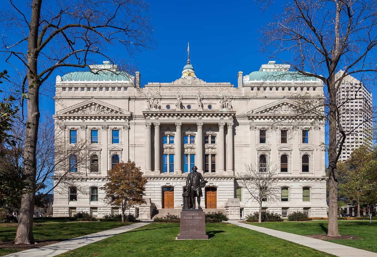 The south end of the Indiana Statehouse in Indianapolis, a domed limestone capitol building, seen at dusk