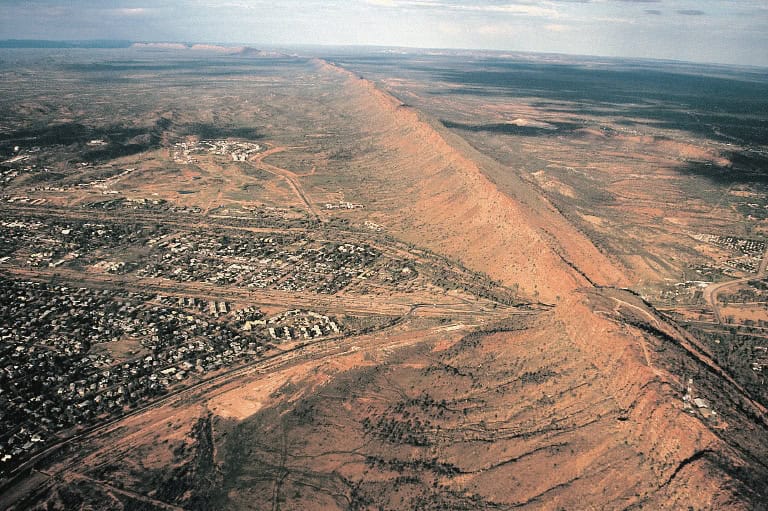 One of the larger settlements on the road that crosses Australia from north to south is Alice Springs. This view shows the transport links passing through Heavitree Gap, beside which the town has been…