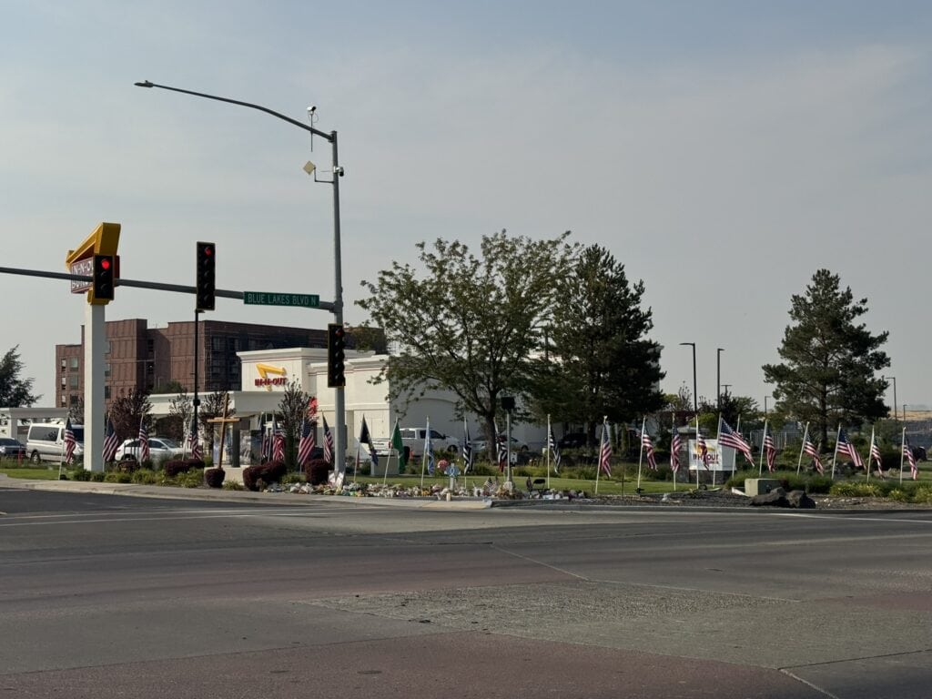 The Twin Falls In-N-Out on August 12, 2026, eleven days after the shooting, with memorial flags
