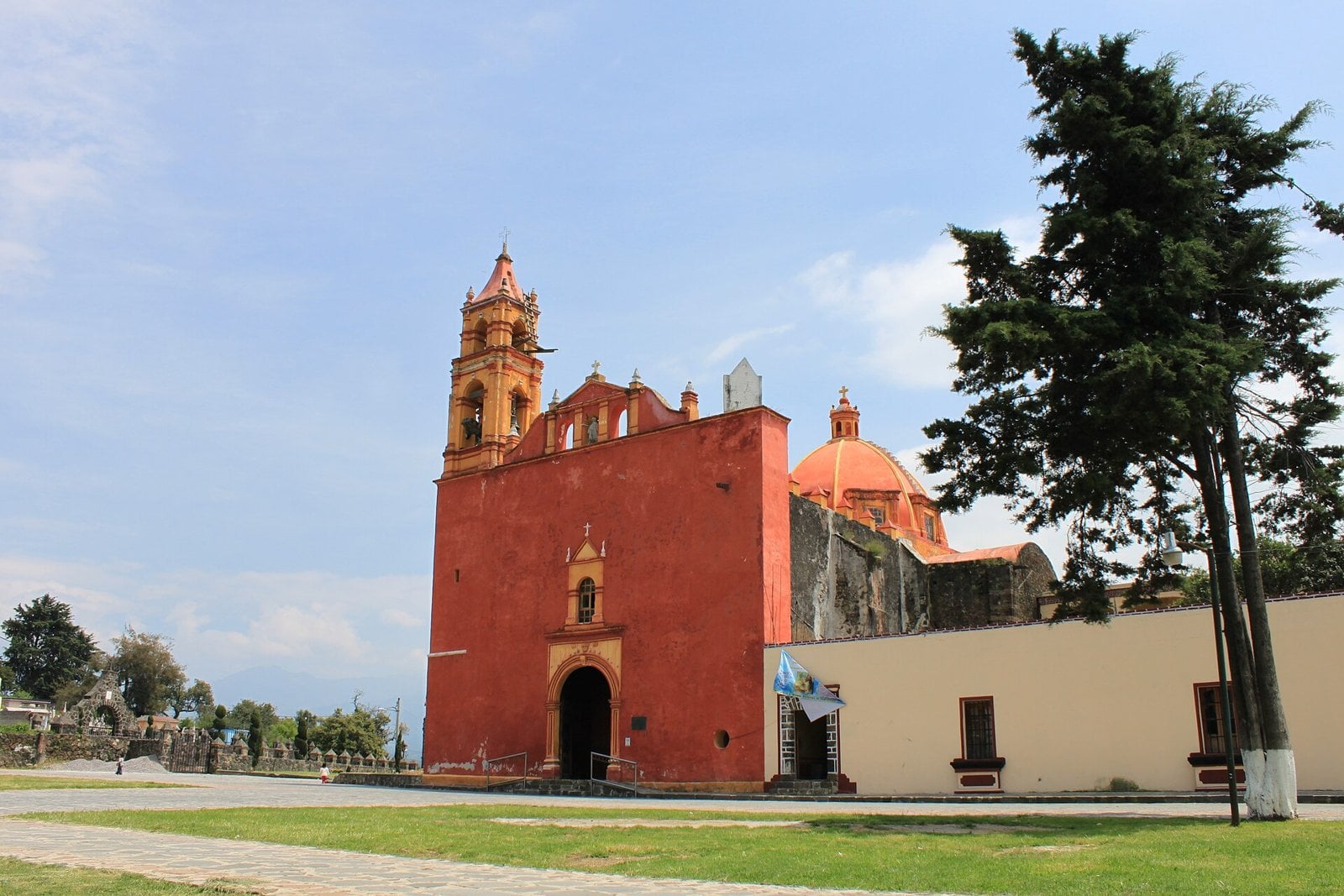 The red facade and bell tower of the Church of San Esteban in Tepetlixpa, State of Mexico