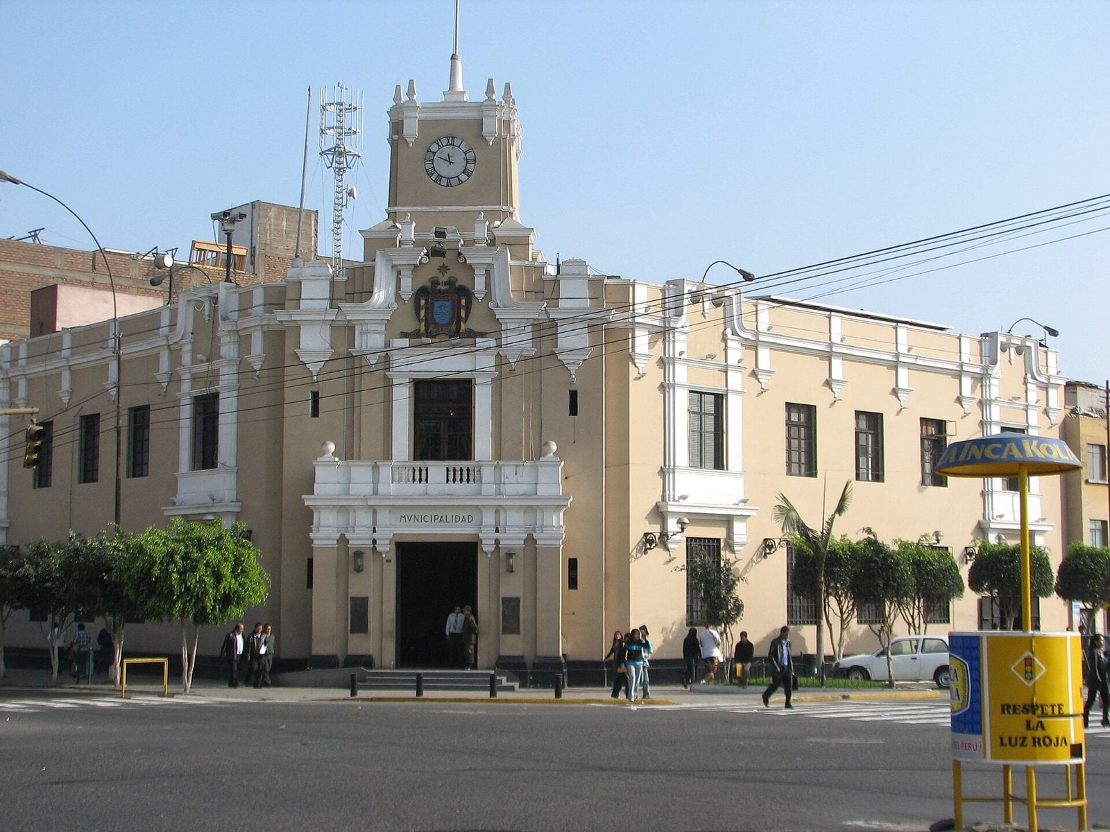 The cream-colored municipal building of La Victoria district in Lima, Peru, with a clock tower, seen from across a street