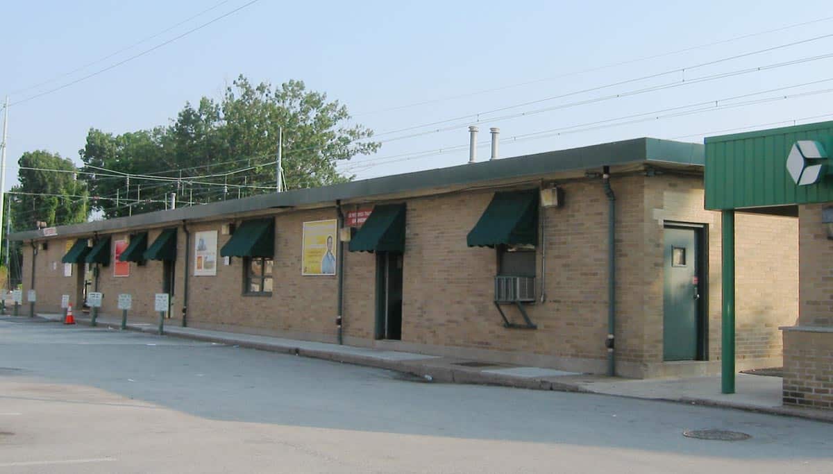 A one-story brick railroad station building with green awnings in Ardmore, Pennsylvania