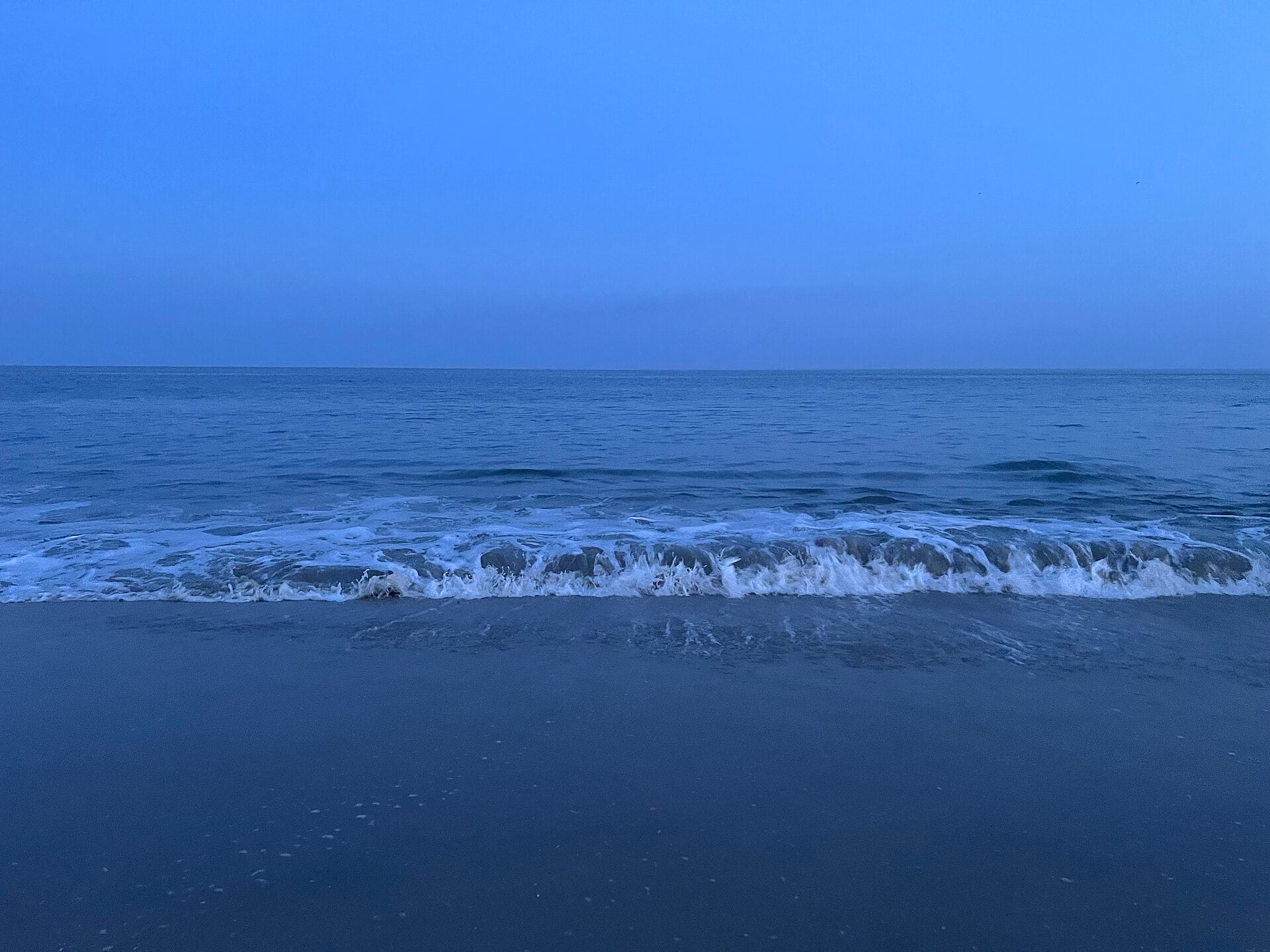 Waves breaking on an empty beach at Cape May, New Jersey, at dusk