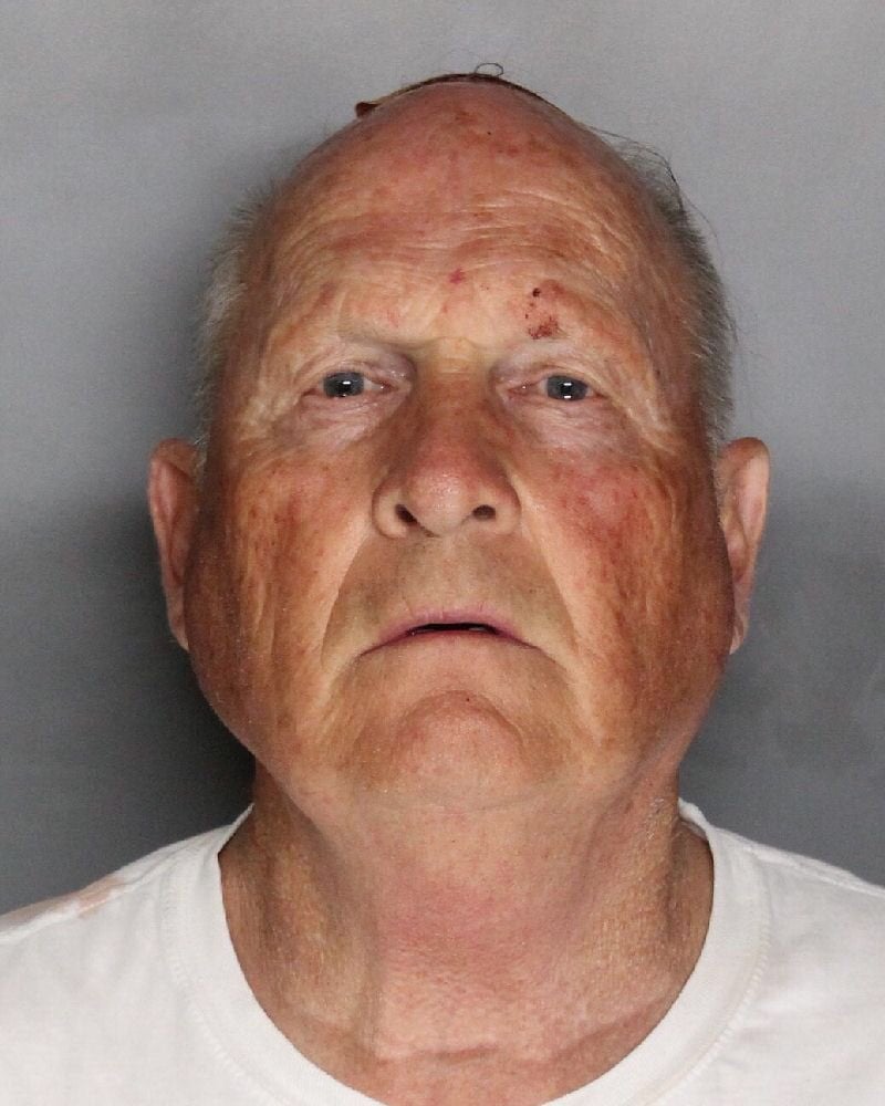 Joseph James DeAngelo, head and shoulders, facing the camera against a plain gray background. He is bald on top with gray hair at the sides, has a small scrape on his forehead and wears a white T-shirt.