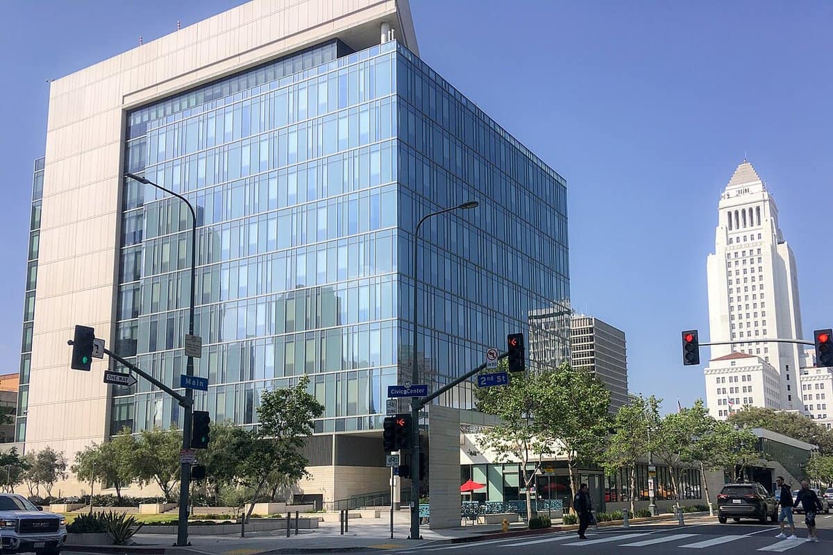 A large modern glass-and-concrete police headquarters building with a wide lawn in front