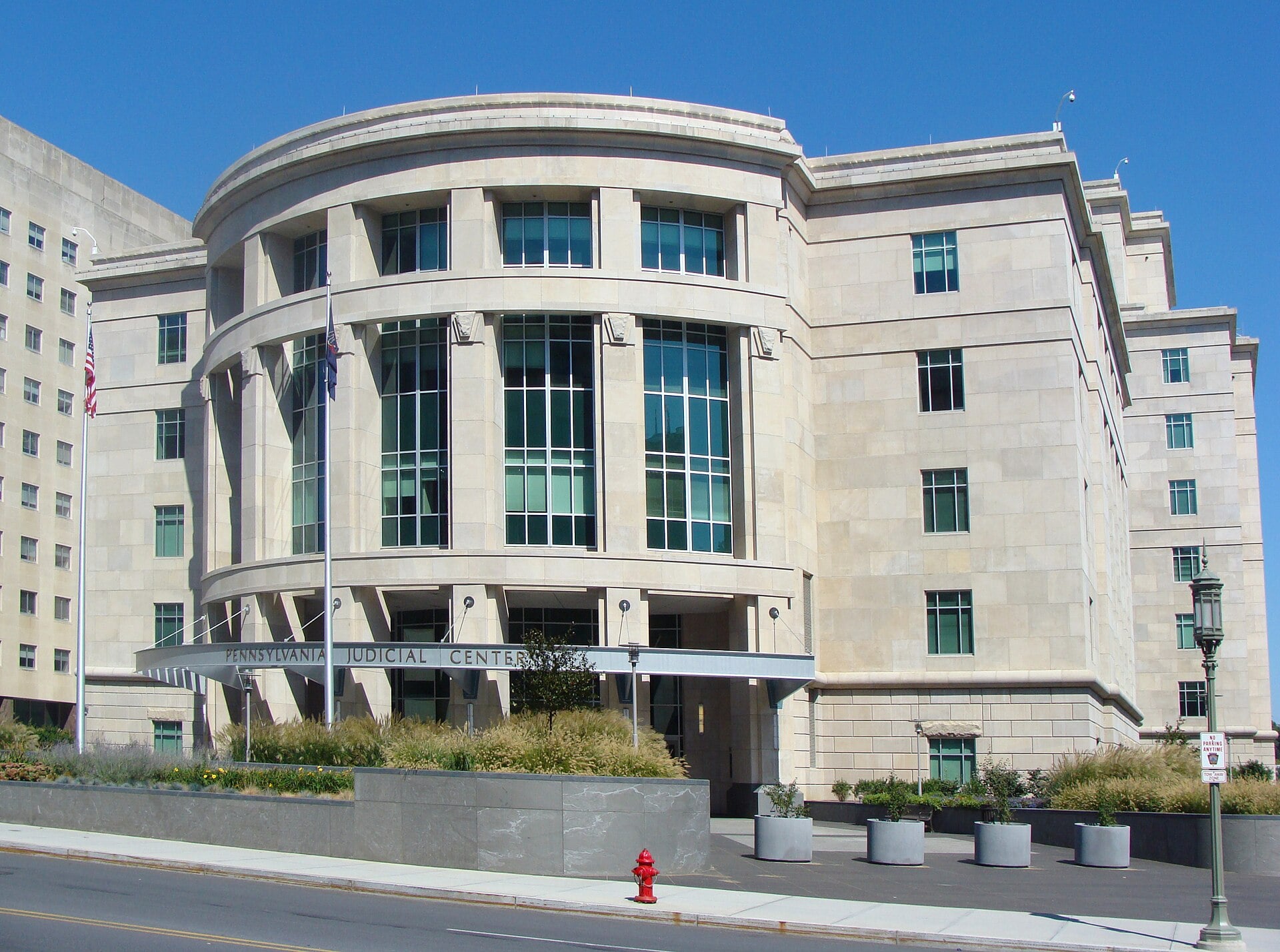 The curved stone and glass facade of the Pennsylvania Judicial Center in Harrisburg under a blue sky