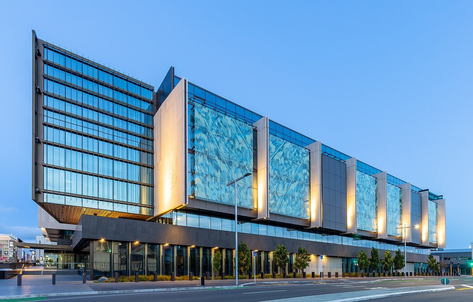 The glass and stone Christchurch Law Courts building lit up at dusk